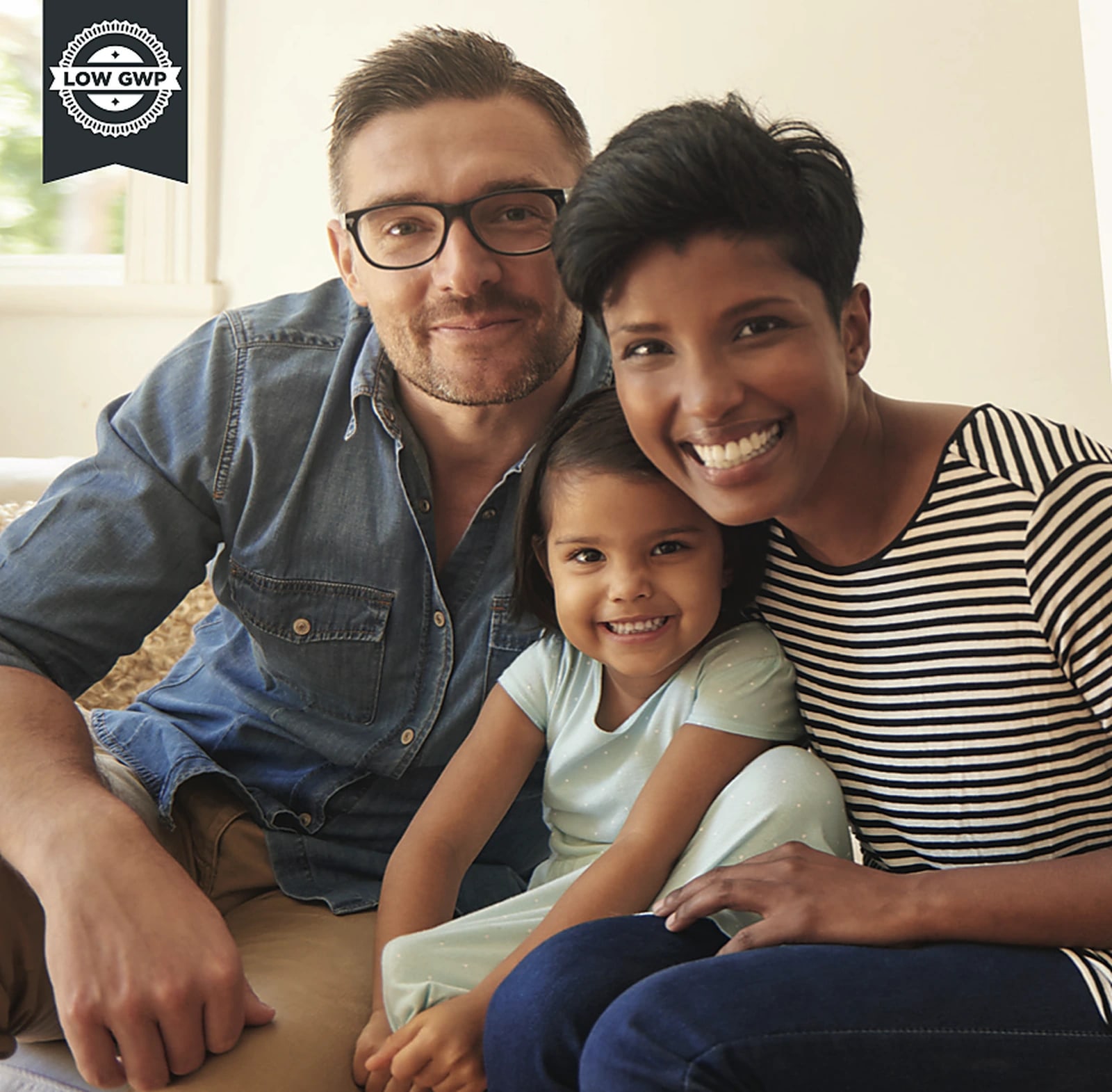 A couple and their young daughter sitting together on a sofa at home